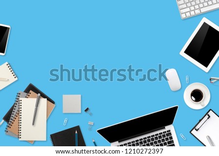 business office desk with workspace, cell phone, tablet, coffee cup, notebook, pencil, on blue pastel background