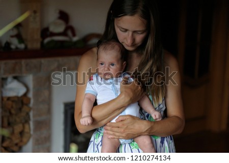 mom gently hugs her baby in her arms