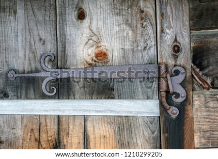 old rusty cast iron hing on a weathered wood door