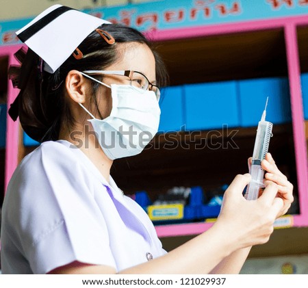 Nurse with medical syringe with needle in ampule getting ready for patient injection