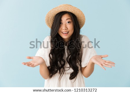 Image of asian young emotional woman isolated over blue background.