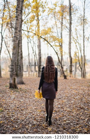 girl is standing back, girl holding leaves, autumn forest, autumn