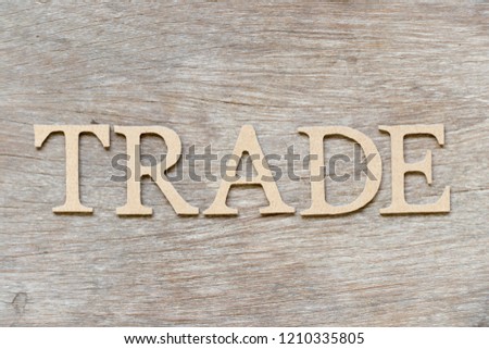Alphabet letter in word trade on wood background