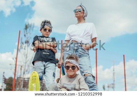 Young woman standing with her sons at playground. Happy family concept.