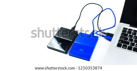 Close up of blue external hard disk drive for connect to laptop, transfer or backup data between computer and HDD. Black hard disc for backup files and important information using USB 3.0 connection