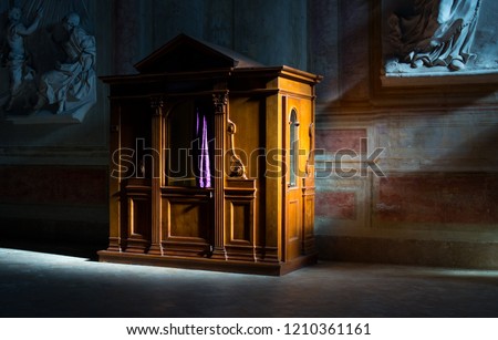 Wooden confessional in the old church in the sunlights Royalty-Free Stock Photo #1210361161