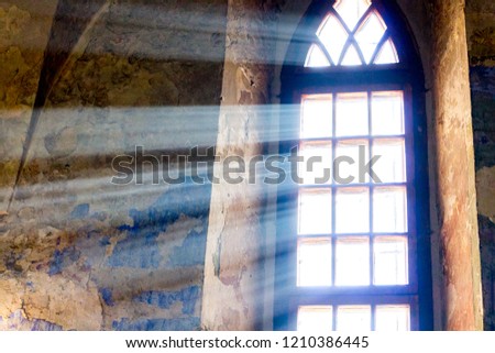 The bright sun rays penetrate the window of the old castle