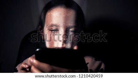 Young girl having her face scanned by her smart phone. Facial recognition concept