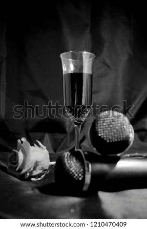Karaoke set on a black background .. Microphones, a glass of wine and a red rose.
