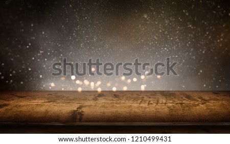 Starry sky with gold bokeh and rustic wooden table for a christmas decoration