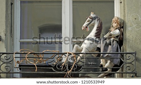 Old wooden horse with doll in window
