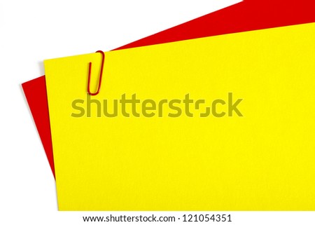 Sheets of color paper connected with red staple on white background