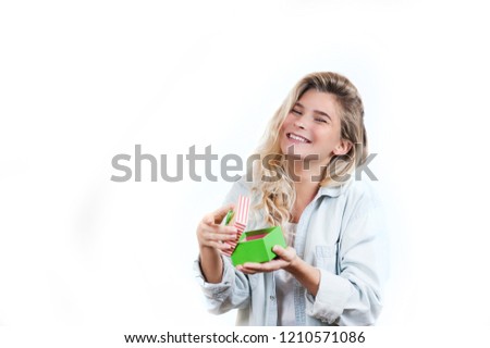 a very beautiful young emotional girl rejoices at the received gift and screams with happiness on a white isolated background