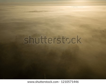 drone image. aerial view of rural area with sun halo above mist. high in the sky