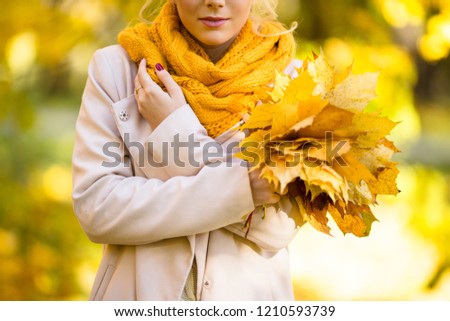 Closeup picture girl with bouquet of yellow maple leaves