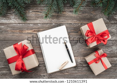 Old wood background with fir branches. Holiday Gifts. Congratulation message notebook. Christmas card. Top view.