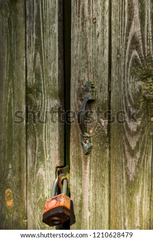 Old iron handle on a wooden entrance door. Retro, vintage.