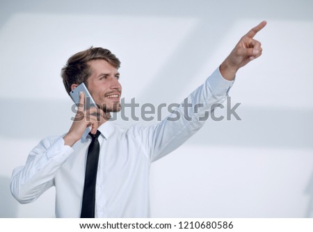 young man talking on the phone is pointing up at something