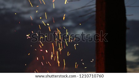 sparks of a fire against the sky at night