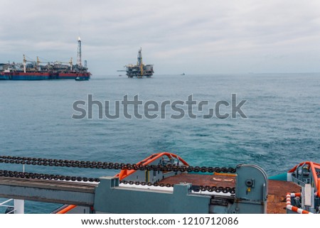 Anchor-handling Tug Supply AHTS vessel during dynamic positioning DP operations near FPSO tanker. Ocean tug job. Royalty-Free Stock Photo #1210712086