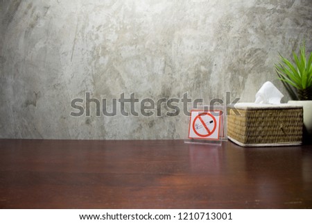 The no smoking sign is placed on a brown table and is decorated beautifully, smoking is dangerous for yourself and others.