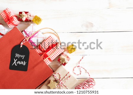 Christmas and New Year's composition. Top view of Gift box and red shopping bag with message tag on a wooden white background.