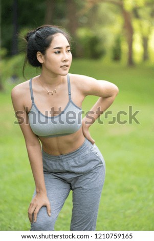Young woman practicing yoga and relaxing in the public garden