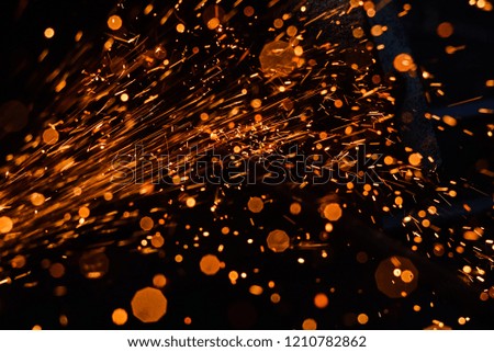 A stream of bright sparks from metal cutting.
