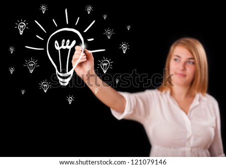 Young woman drawing light bulb on whiteboard