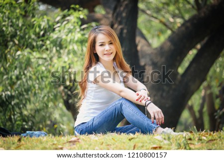 Asian woman wearing a T-shirt and jeans. Are happy in the public park at Bangkok Thailand