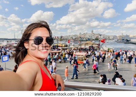 Beautiful Chinese woman poses with view of Galata Tower at Eminonu district in Istanbul,Turkey