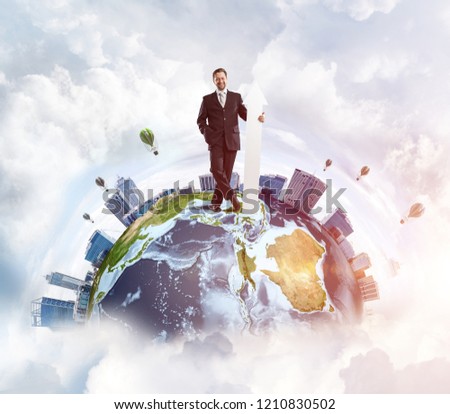 Conceptual image of young successful business man in suit pointing aside by means of big white banner in form of arrow while standing on Earth globe. Elements of this image are furnished by NASA.