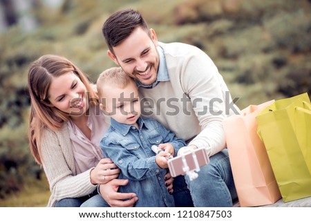 Happy family taking selfie outdoor in a city park. Spend time together and enjoy.