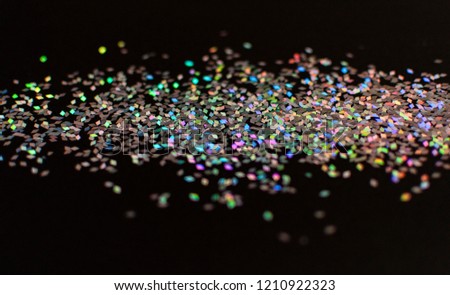 Multicolor glitter or confetti rhombuses on a black background, for carnival, night party invitation or festive background