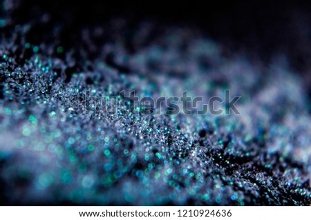 Turquoise glitter on a black background, snow or diamond effect. For christmas, new year, carnival, night party invitation or festival background