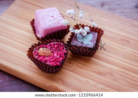Hand made chocolate sweets on wooden background. Close up shallow depth of field sweet food image.