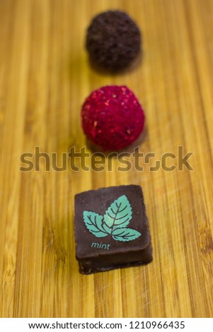 Hand made chocolate sweets on wooden background. Close up shallow depth of field sweet food image.