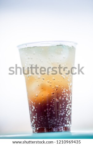 A glass of water, a close-up view of cold ice, a glass of soft drinks (soft drinks, alcohol, nectar) placed on a wooden table, managed by the client or eaten to refresh the body.