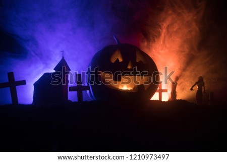 Scary view of zombies at cemetery dead tree, moon, church and spooky cloudy sky with fog, Horror Halloween concept with glowing pumpkin. Selective focus