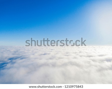 Aerial view White clouds in blue sky. Top view. View from drone. Aerial bird's eye. Aerial top view cloudscape. Texture of clouds. Look from above. Sunrise over clouds
