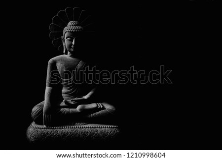 Statue of Buddha sitting in meditation with black space on the left hand side Royalty-Free Stock Photo #1210998604