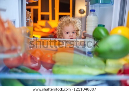 Toddler stealing food from fridge.  Picture taken from the iside of fridge.