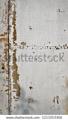 Abstract background of white and green paint chipping off of a cement wall.
