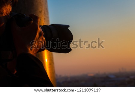 close up senior man photographer he's shooting picture with sunset sky scene on the roof