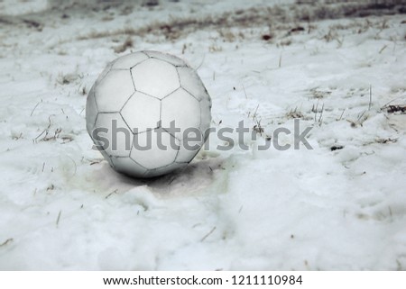 White soccer ball on the first snow. Close-up shot.