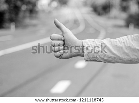 Thumb up gesture try stop car road background. Hand gesture hitchhiking. Make sure you know right gestures to stop car. Thumb up sign not work in many parts of world. Autostop travel. Pick me up.