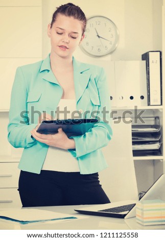 Office worker woman is signing contract at office.
