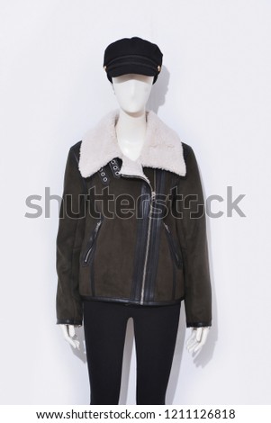 female in jacket with black jeans with hat on mannequin-white background 
