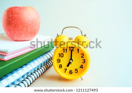 Back to school concept,book,apple and clock on gray background. Education