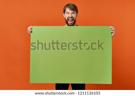 screaming man holds green mockup poster                         